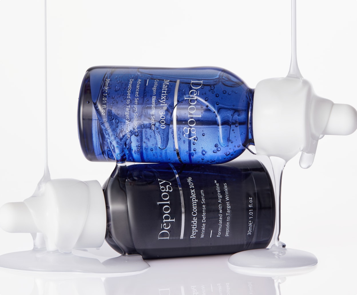 Two skincare serum bottles with droppers on a white background