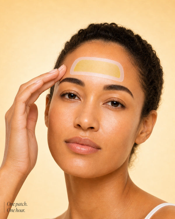 Woman with a patch on her forehead against a beige background